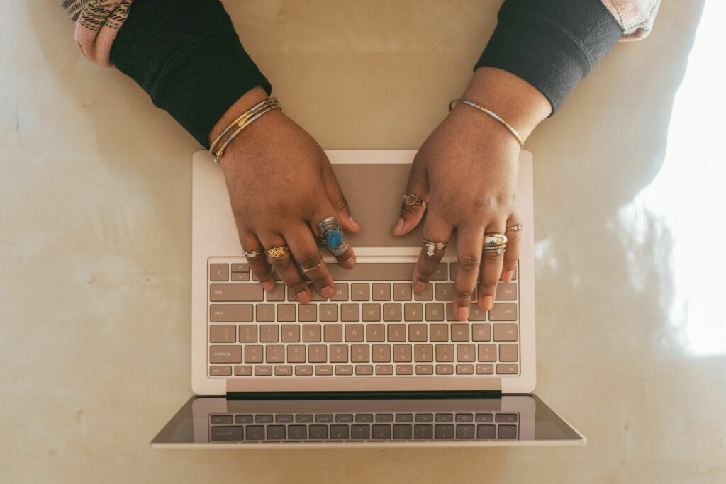 Une femme portant de nombreuses bagues rédige un article sur la pyramide inversée en SEO